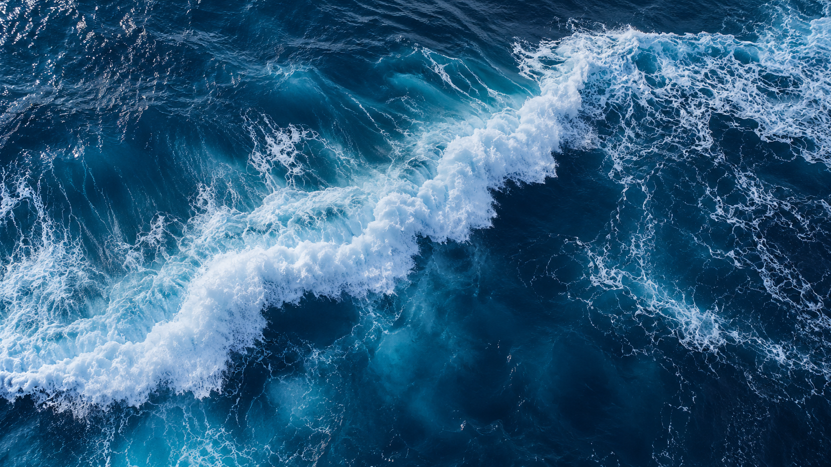 Deep blue ocean with a sweeping white wave